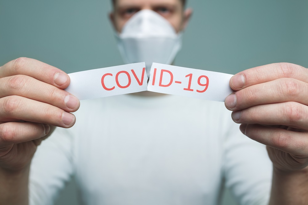 Man wearing a respiratory mask holding the Coronavirus Covid-19 sign