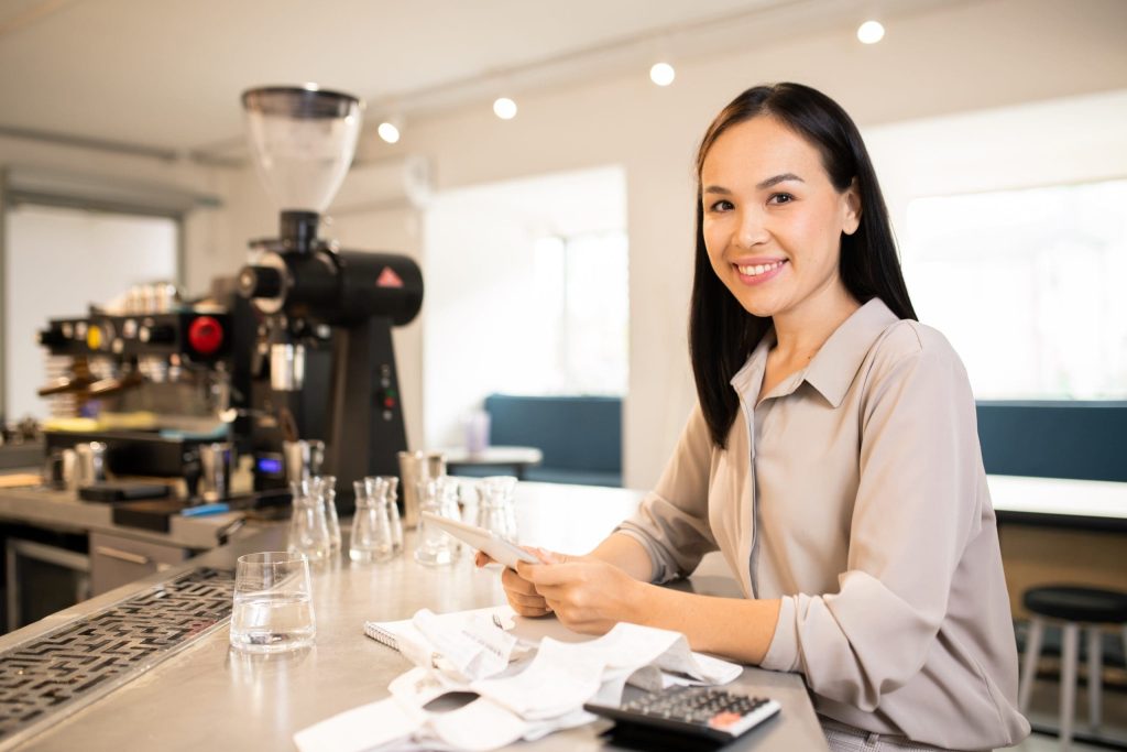 Young successful manager or accountant of restaurant counting earnings